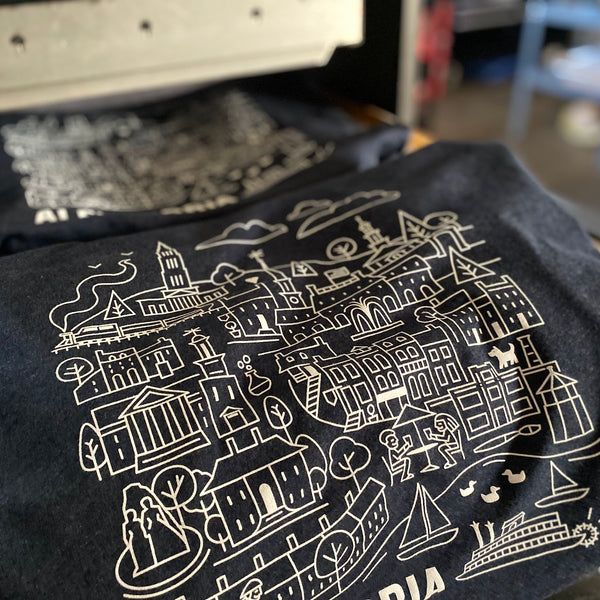 Alexandria city illustration tees in white ink on Midnight Navy Next Level 6210, stacked after printing at RVA Threads screen printing, Virginia