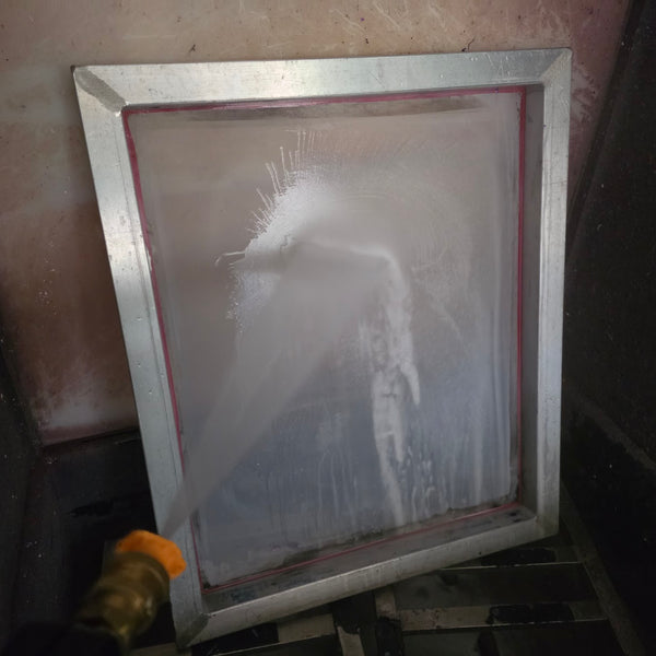Aluminum screen frame in the washout booth getting rinsed with the spray hose at RVA Threads screen printing, Virginia