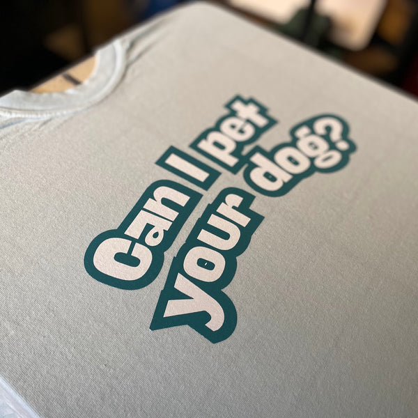 Can I Pet Your Dog design in teal and white ink on a light tee on the press pallet at RVA Threads screen printing, Virginia