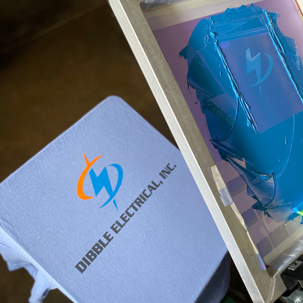 Dibble Electrical, Inc. logo in orange and blue ink on a violet tee with the blue screen raised at RVA Threads screen printing, Virginia