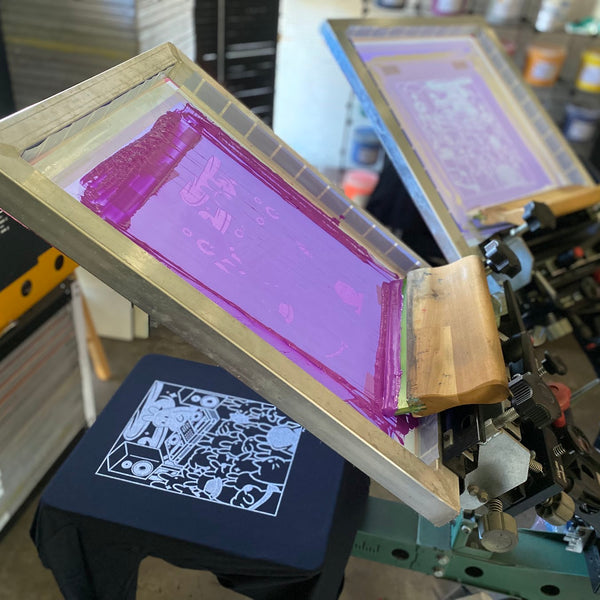 DJ bunny design screen with purple ink raised over a printed black tee at RVA Threads screen printing, Virginia
