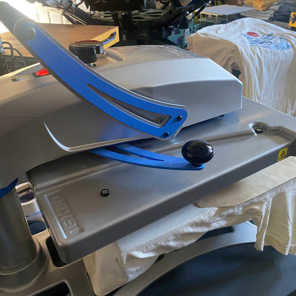Heat press clamped down on a printed tee on the platen to finish the job at RVA Threads screen printing, Virginia
