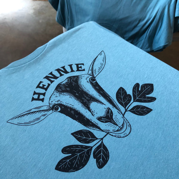 Hennie goat illustration with leaves in black ink on a blue tee at RVA Threads screen printing, Virginia