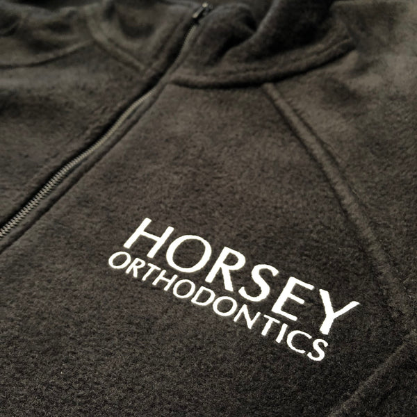 Horsey Orthodontics logo in white ink on a black quarter zip pullover at RVA Threads screen printing, Virginia