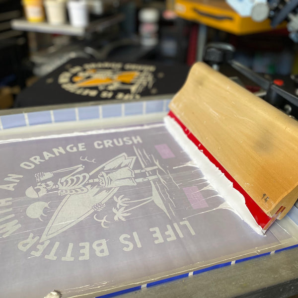 Life Is Better With An Orange Crush screen with squeegee on the press at RVA Threads screen printing, Virginia