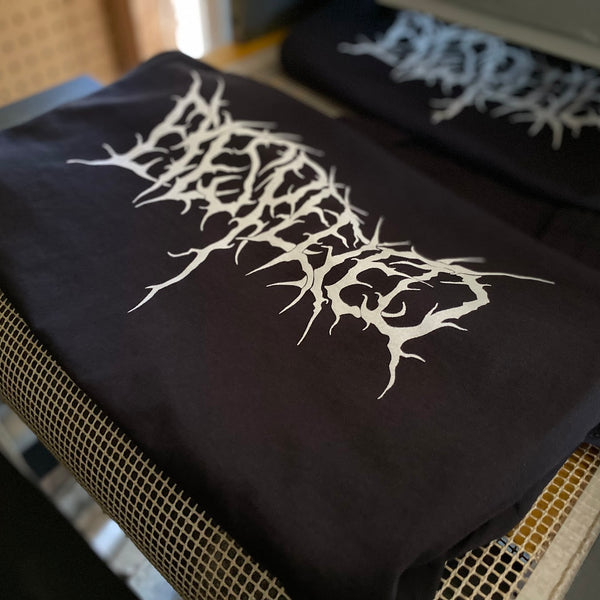Metal band logo tees in white ink on black, stacked after printing at RVA Threads screen printing, Virginia