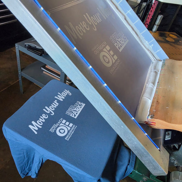 Move Your Way tee for Henrico Recreation and Parks in blue with white ink on the press, screen raised at RVA Threads screen printing, Virginia