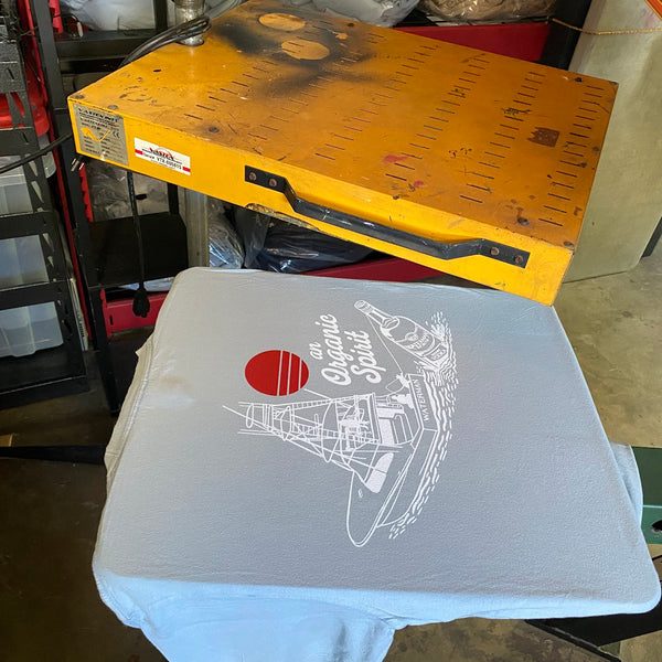 An Organic Spirit boat design white underbase on a tee under the flash dryer at RVA Threads screen printing, Virginia