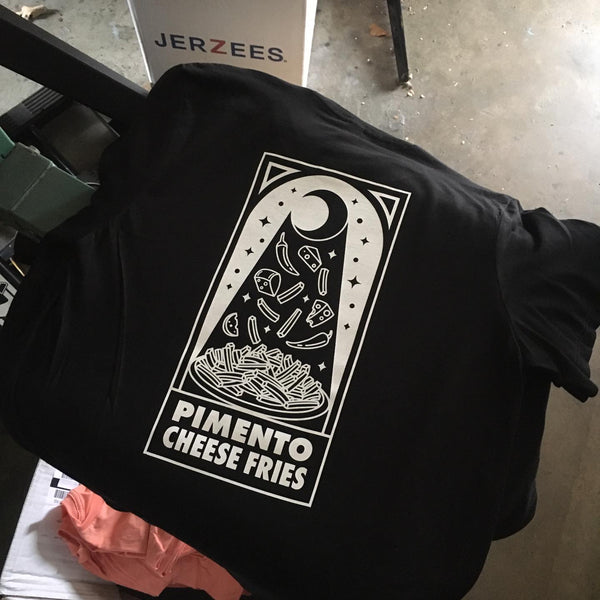Pimento Cheese Fries design in white ink on a black tee, laid flat at RVA Threads screen printing, Virginia