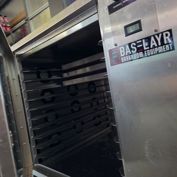 Stainless steel screen drying cabinet with the door open showing empty racks and fans at RVA Threads screen printing, Virginia
