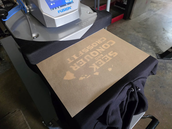 Seek and Conquer CrossFit print on a Black Champion S700 hoodie on the Fusion heat press under a cover sheet at RVA Threads screen printing, Virginia