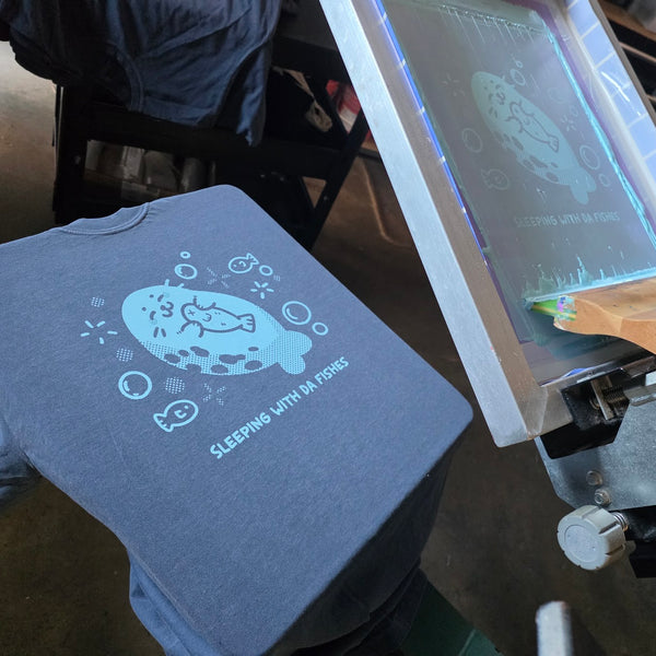 Sleeping With Da Fishes seal print in light blue ink on a Denim Comfort Colors 1717 tee at RVA Threads screen printing, Virginia
