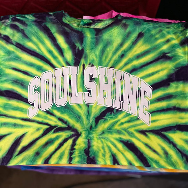 Soulshine arch lettering in white ink on a green and purple tie-dye tee at RVA Threads screen printing, Virginia