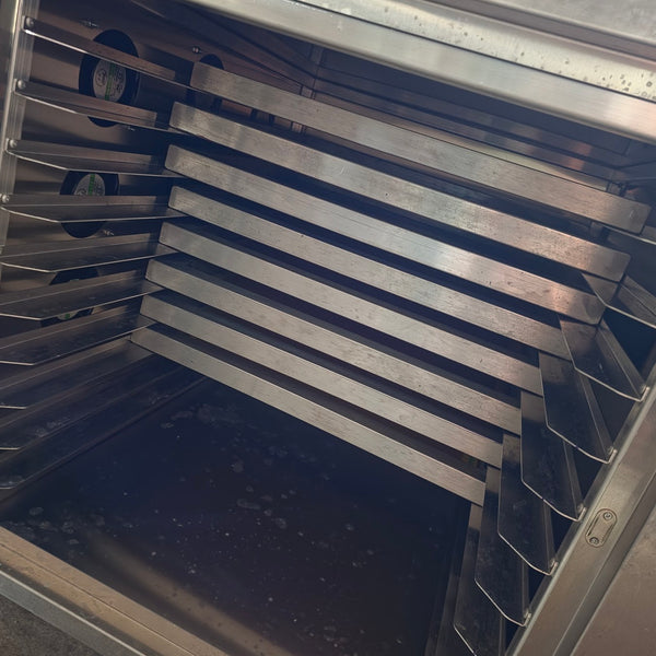 Empty racks and circulation fans inside the stainless steel screen drying cabinet at RVA Threads screen printing, Virginia