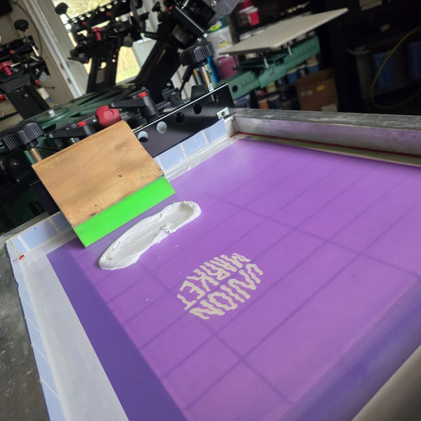 Union Market screen loaded with white ink and a squeegee, ready to print at RVA Threads screen printing, Virginia