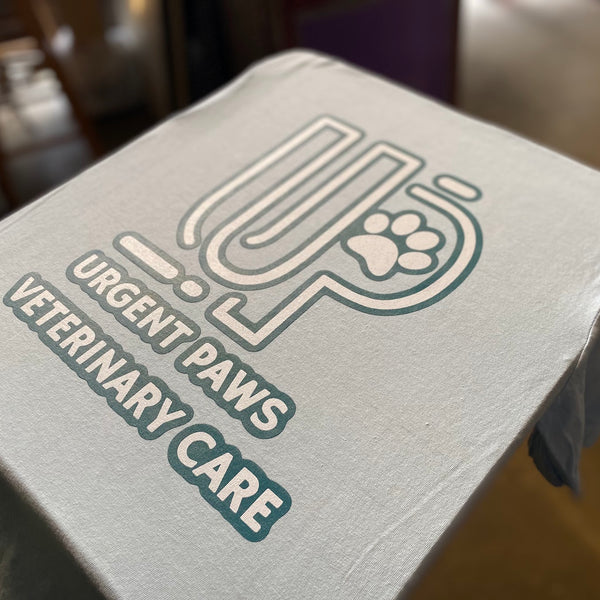 Urgent Paws Veterinary Care logo on a white tee on the press pallet at RVA Threads screen printing, Virginia