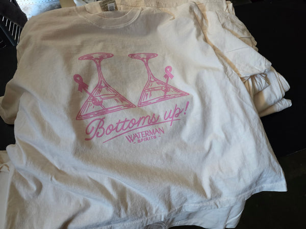 Waterman Spirits Bottoms Up martini glass print in pink ink on a stack of Ivory Comfort Colors tees at RVA Threads screen printing, Virginia