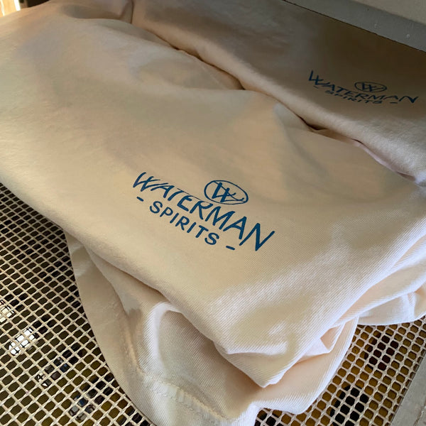 Waterman Spirits natural tees printed in blue ink riding the conveyor dryer belt at RVA Threads screen printing, Virginia