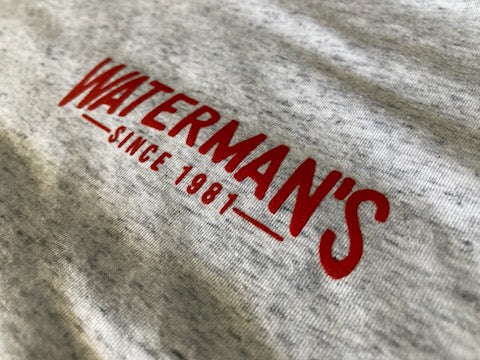 Waterman's Since 1981 logo in red ink on an ash heather tee, close up at RVA Threads screen printing, Virginia