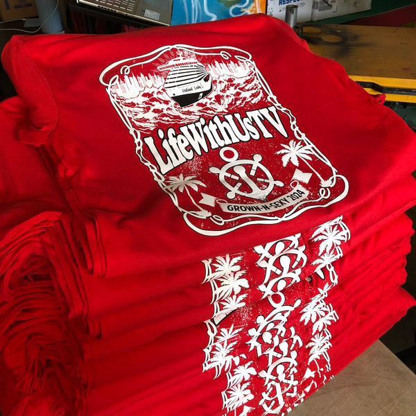 White ink crest design with sleeve prints on red tees, stacked after printing at RVA Threads screen printing, Virginia