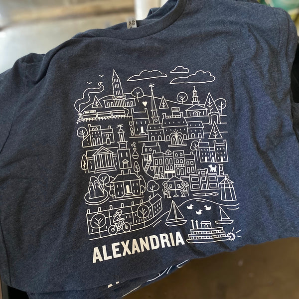 Alexandria city illustration in white ink on a Midnight Navy Next Level 6210 tee, laid out after printing at RVA Threads screen printing, Virginia