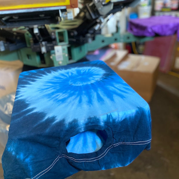 Blank blue tie-dye tee loaded on the press pallet and ready to print at RVA Threads screen printing, Virginia