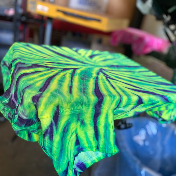 Blank green and purple tie-dye tee loaded on the press pallet and ready to print at RVA Threads screen printing, Virginia