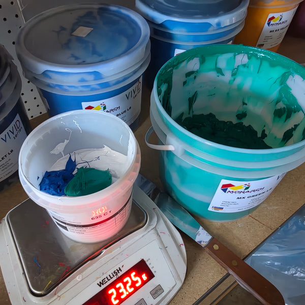 Blue and green Monarch Vivid plastisol inks being mixed in a cup on a digital scale at RVA Threads screen printing, Virginia