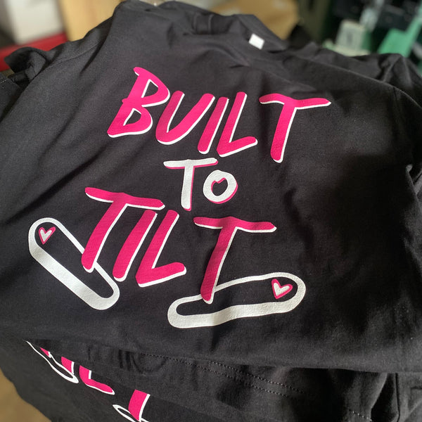 Built to Tilt design in pink and white ink on black Bella+Canvas 3001 tees, stacked after printing at RVA Threads screen printing, Virginia