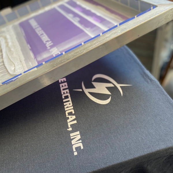 Dibble Electrical, Inc. logo in white ink on a black tee under the screen at RVA Threads screen printing, Virginia