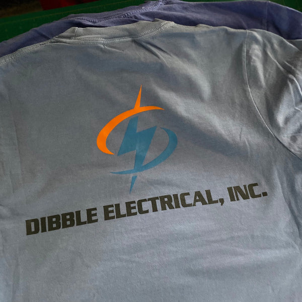 Dibble Electrical, Inc. logo in orange, blue and charcoal ink on a gray tee laid over a violet tee at RVA Threads screen printing, Virginia