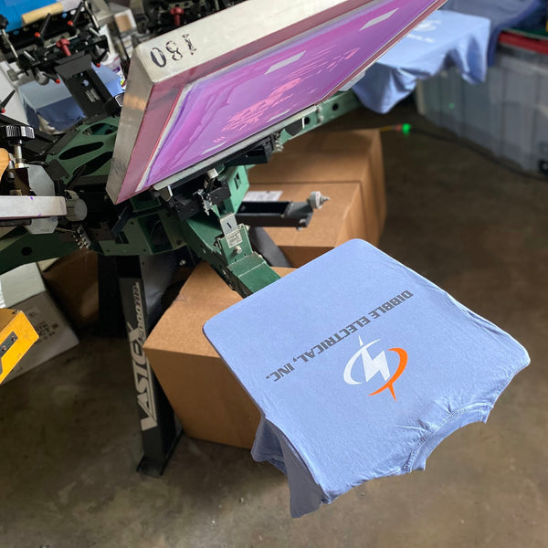 Dibble Electrical, Inc. tee in violet on the six-color press with the screen raised above at RVA Threads screen printing, Virginia