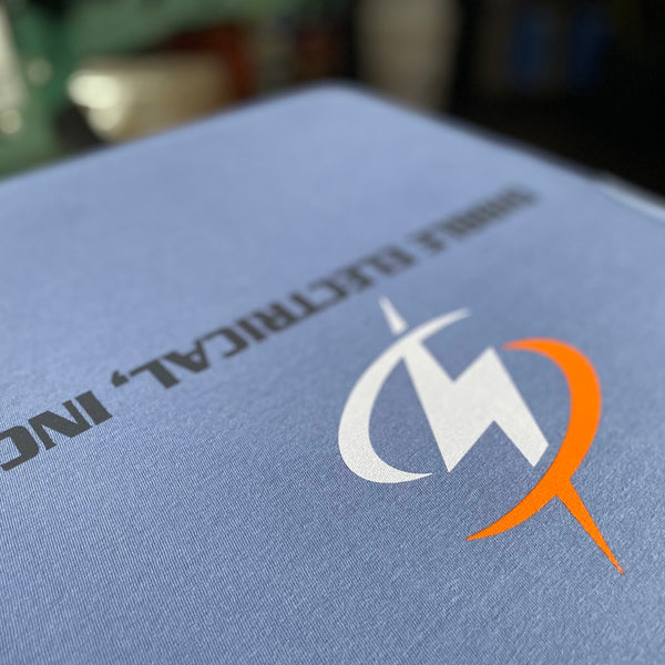 Dibble Electrical, Inc. lightning logo in white, orange and charcoal ink on a steel blue tee at RVA Threads screen printing, Virginia
