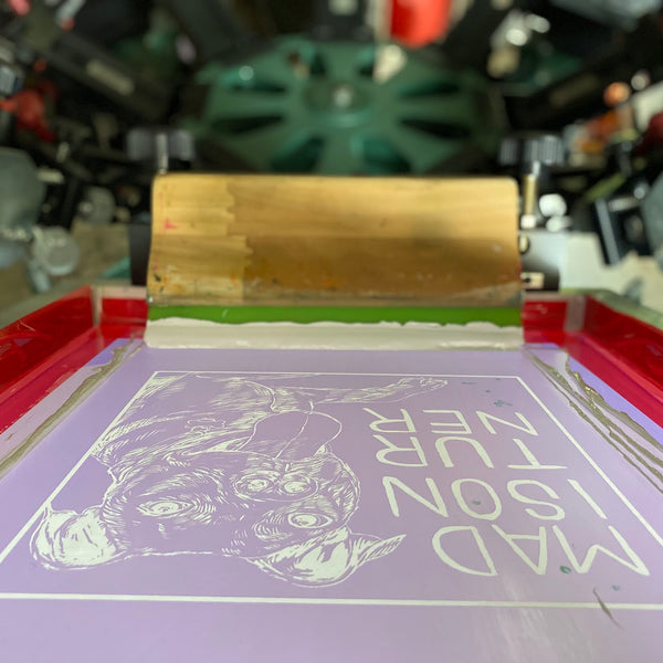 Dog portrait design screen with white ink and squeegee on the press at RVA Threads screen printing, Virginia