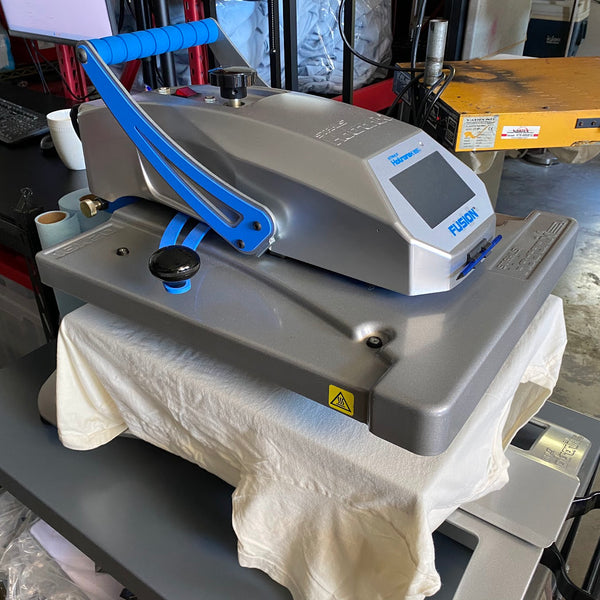 Heat press clamped down on a natural tee to finish the print at RVA Threads screen printing, Virginia