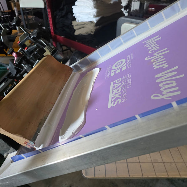 Henrico Recreation and Parks screen flooded with white ink, squeegee resting on the press at RVA Threads screen printing, Virginia