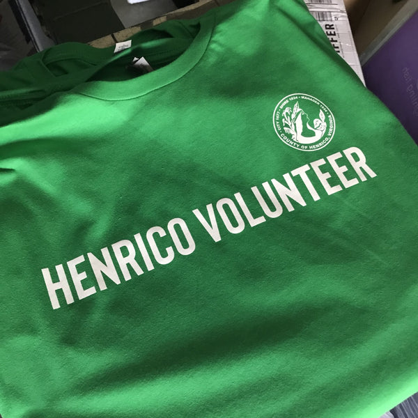 Henrico Volunteer lettering and seal in white ink on a green tee, close up at RVA Threads screen printing, Virginia