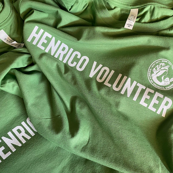 Henrico Volunteer lettering in white ink on green tees, laid out after printing at RVA Threads screen printing, Virginia