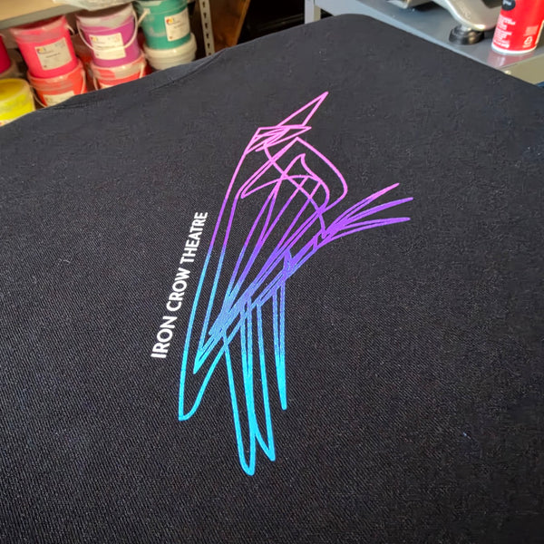 Iron Crow Theatre crow print in a purple to blue blend with white text on a black tee at RVA Threads screen printing, Virginia
