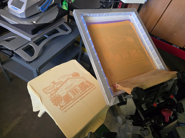 Lemon Drop Inn screen raised over a printed Butter Comfort Colors 6030 pocket tee on the press at RVA Threads screen printing, Virginia