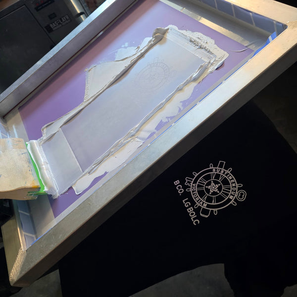 Logistics BOLC insignia in white ink on a black Independent Trading SS3000 crewneck under the screen at RVA Threads screen printing, Virginia
