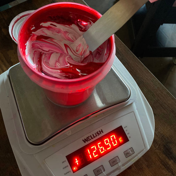 Cup of magenta ink stirred with a spatula on a digital scale while mixing at RVA Threads screen printing, Virginia