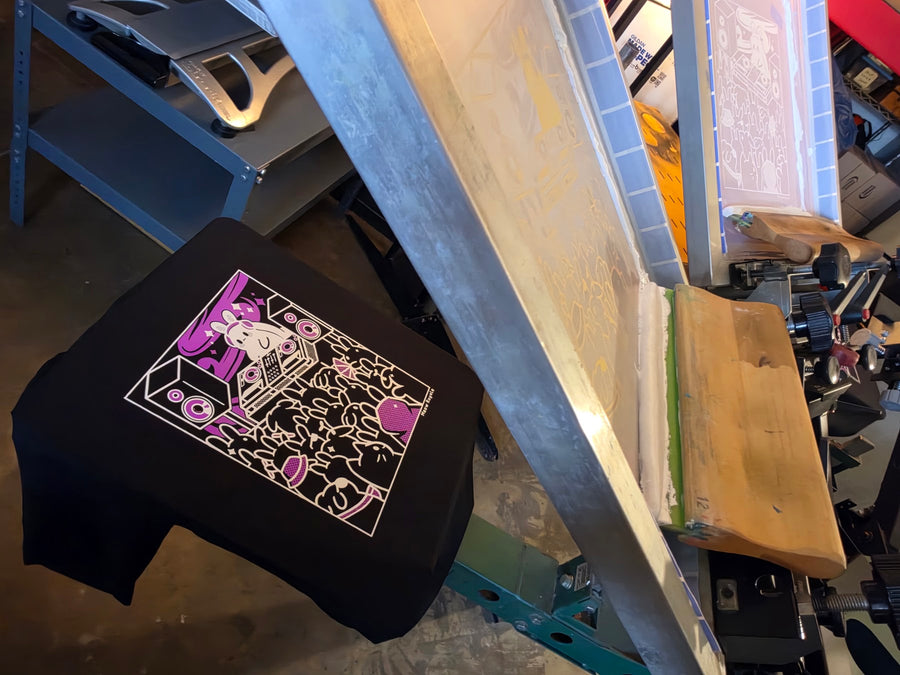Meow Royale DJ Rabbit print in white and purple ink on a black Gildan 2000 tee with the screen lifted at RVA Threads screen printing, Virginia