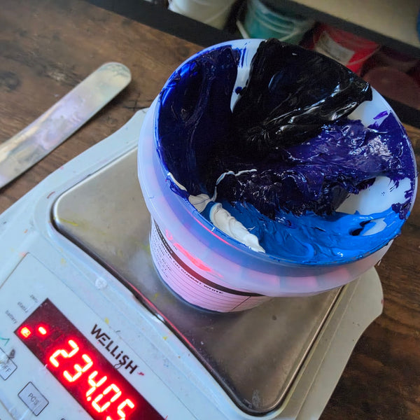 Cup of purple, blue, black and white ink on a digital scale while mixing a custom color at RVA Threads screen printing, Virginia