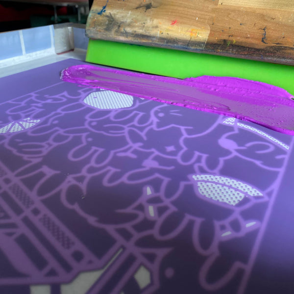 Purple ink screen with the squeegee for the DJ bunny design, close up at RVA Threads screen printing, Virginia