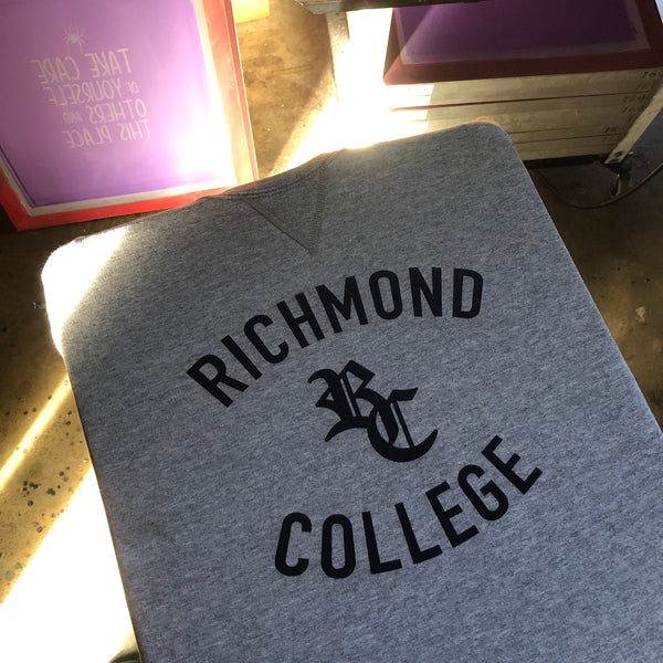 Richmond College lettering in black ink on a heather gray sweatshirt at RVA Threads screen printing, Virginia