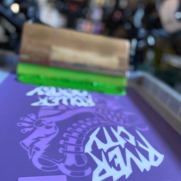 River City Roller Derby screen with green ink and the squeegee on the press at RVA Threads screen printing, Virginia
