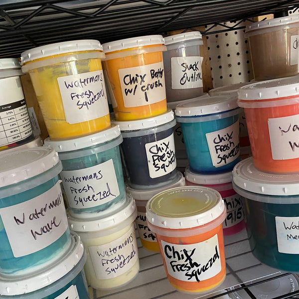 Shelf of labeled custom mixed ink tubs for repeat client jobs at RVA Threads screen printing, Virginia