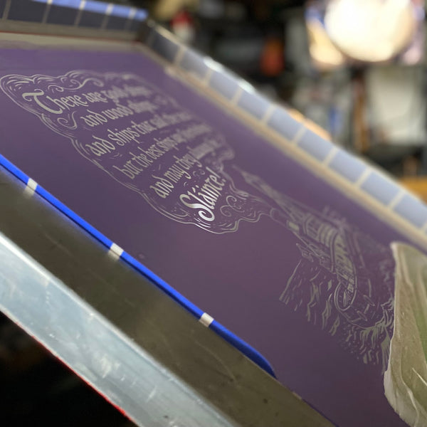 Slainte toast screen with white ink and the squeegee on the press at RVA Threads screen printing, Virginia