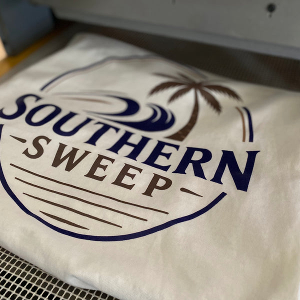 Southern Sweep palm tree logo printed in navy ink on a natural tee on the press pallet at RVA Threads screen printing, Virginia